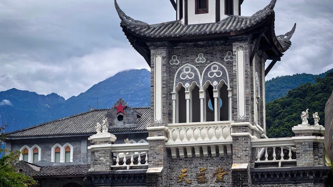 The Moxi Catholic church, a Gothic stone facade topped with a tiered Chinese roof and cross.
