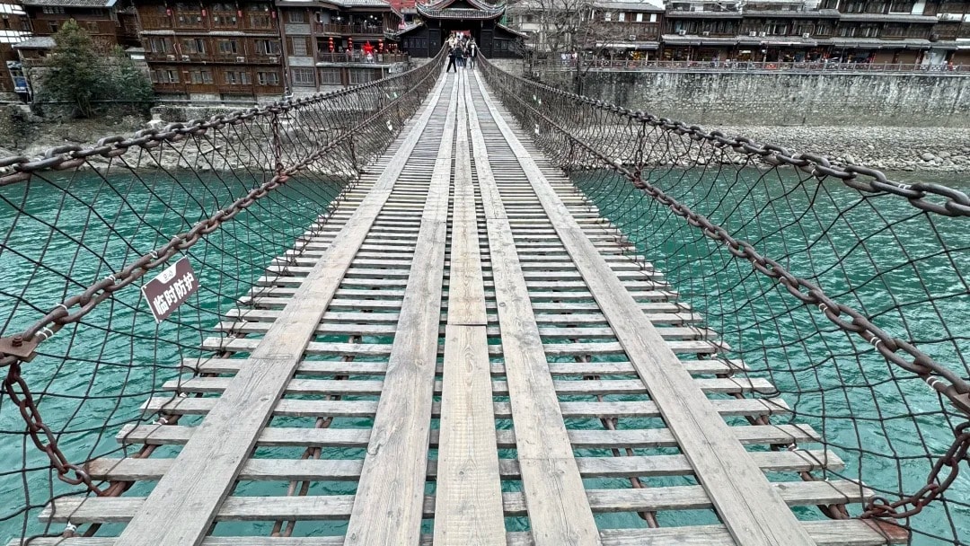 The plank deck and iron chains of Luding Bridge stretching across the Dadu River.