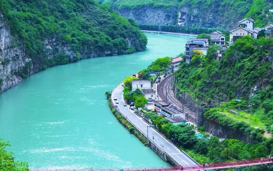 Cyclist riding through the bamboo-lined river valley on the Dayi Xin-Ma-Tai loop near Chengdu