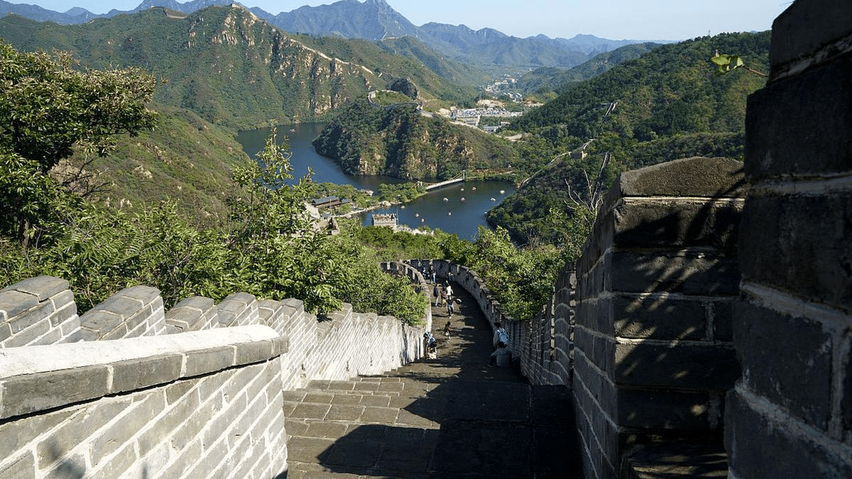 Traditional stone watchtower and tiled roof architecture in a rural Chinese mountain village.