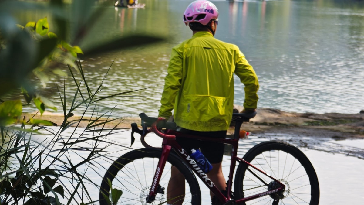 Rider looking out over the river as bamboo rafts drift past