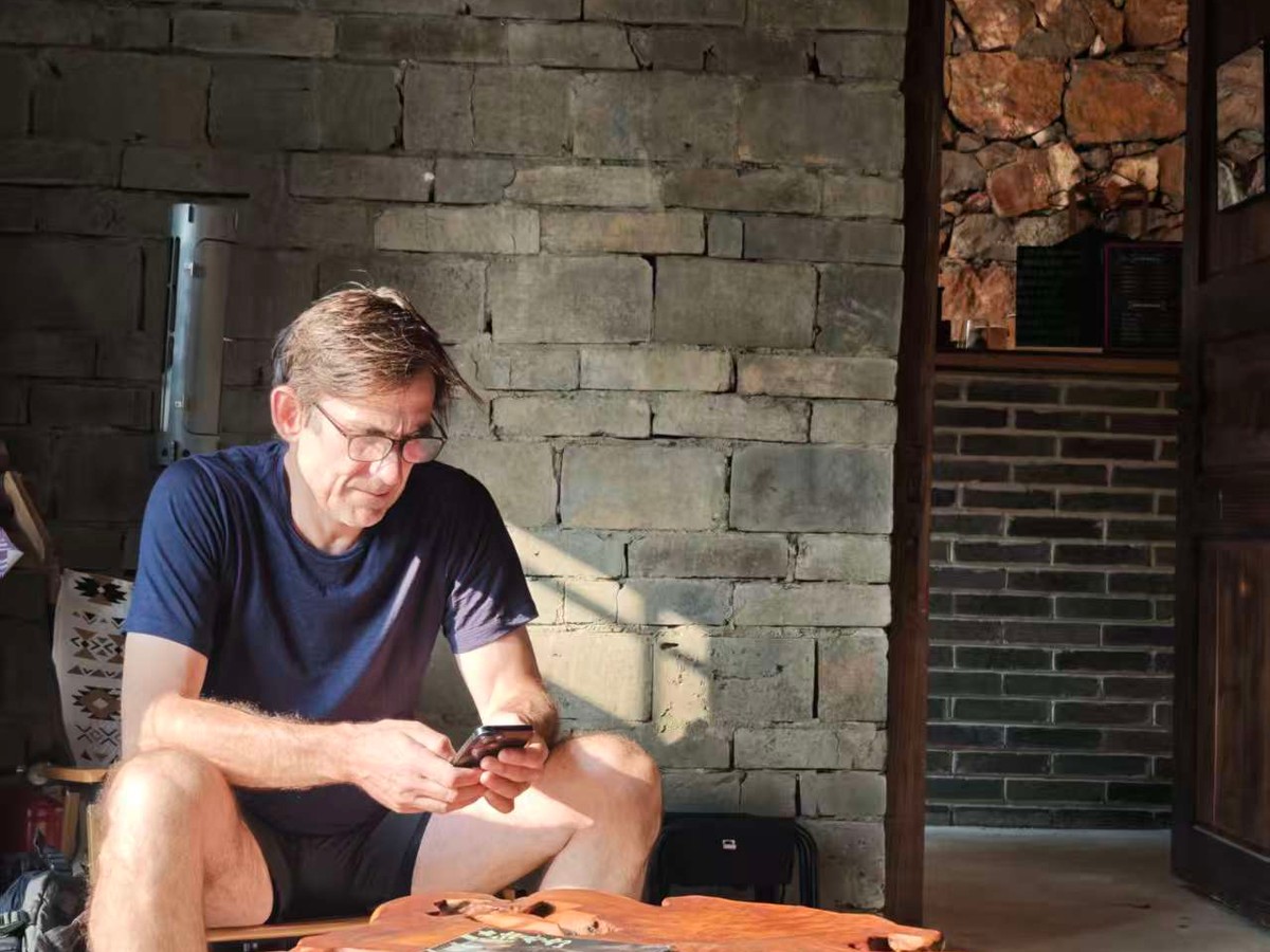 Guest resting at a live-edge wooden table in a stone-walled village cafe