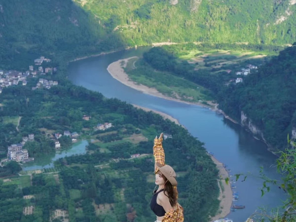 Guest on the summit rock reaching up, the river curving through the valley below