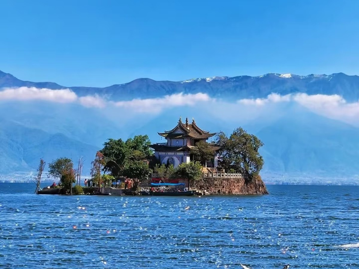 Temple islet on Erhai with seagulls on the water and Cangshan under a band of cloud