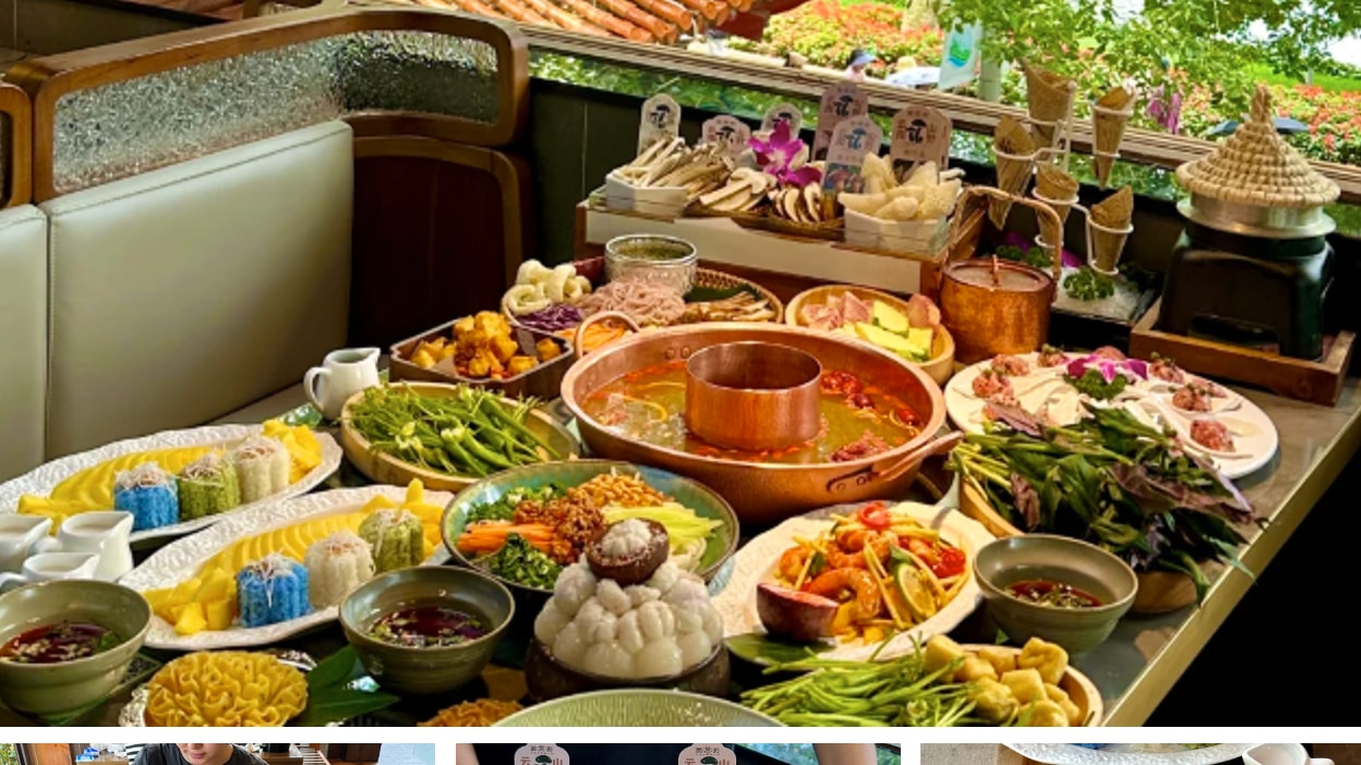 A large spread of colorful Yunnan cuisine on a balcony overlooking a traditional garden.