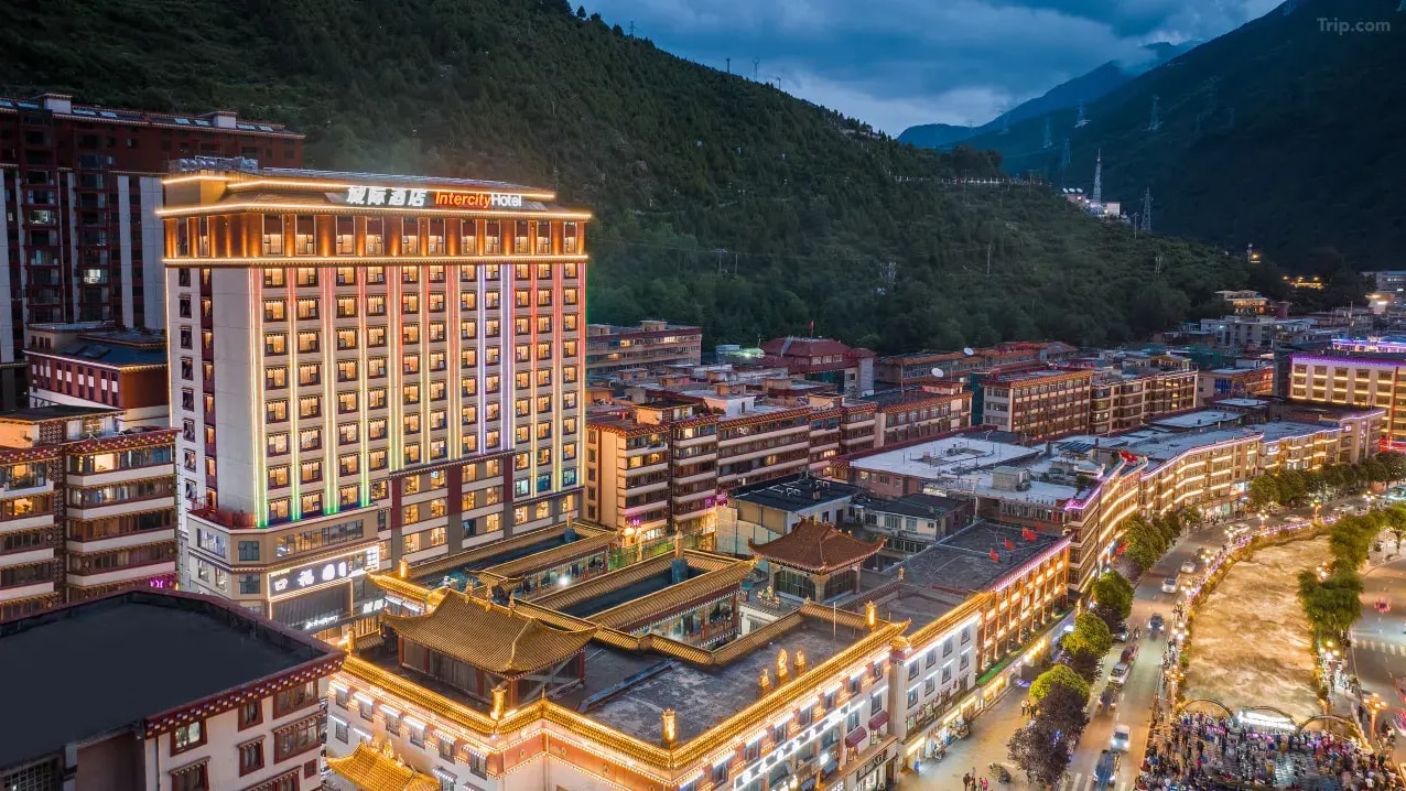 Kangding Chengji Hotel rising above the town rooftops in its steep green valley.