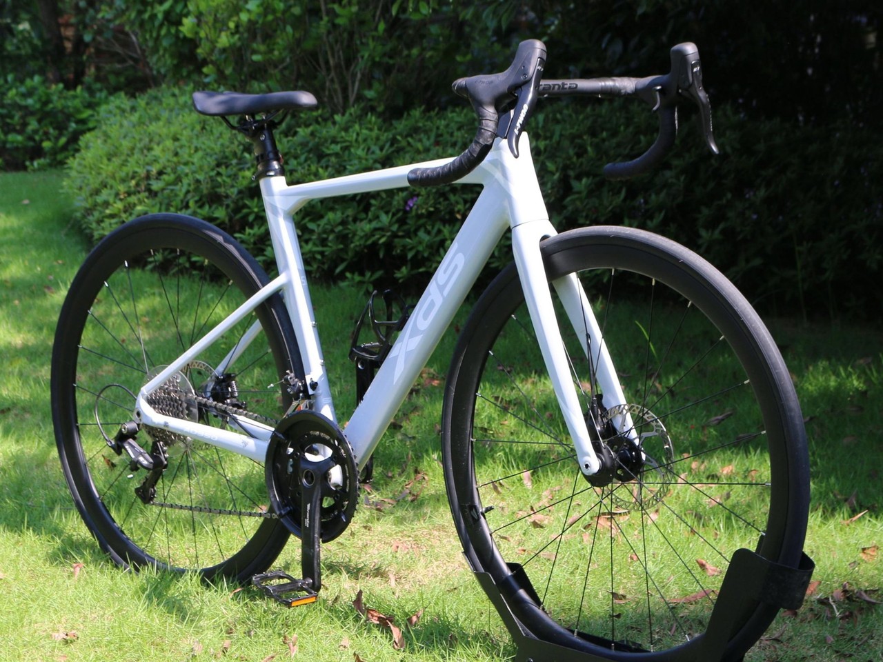 XDS AD350 road bike with disc brakes parked on a green grass lawn.