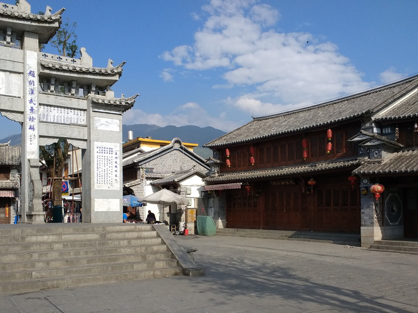 Stone gateway and Bai-style buildings on a square in Xizhou Ancient Town