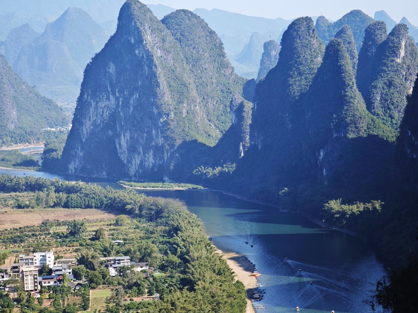 The Li River winding between karst peaks with rafts on the water, seen from the summit