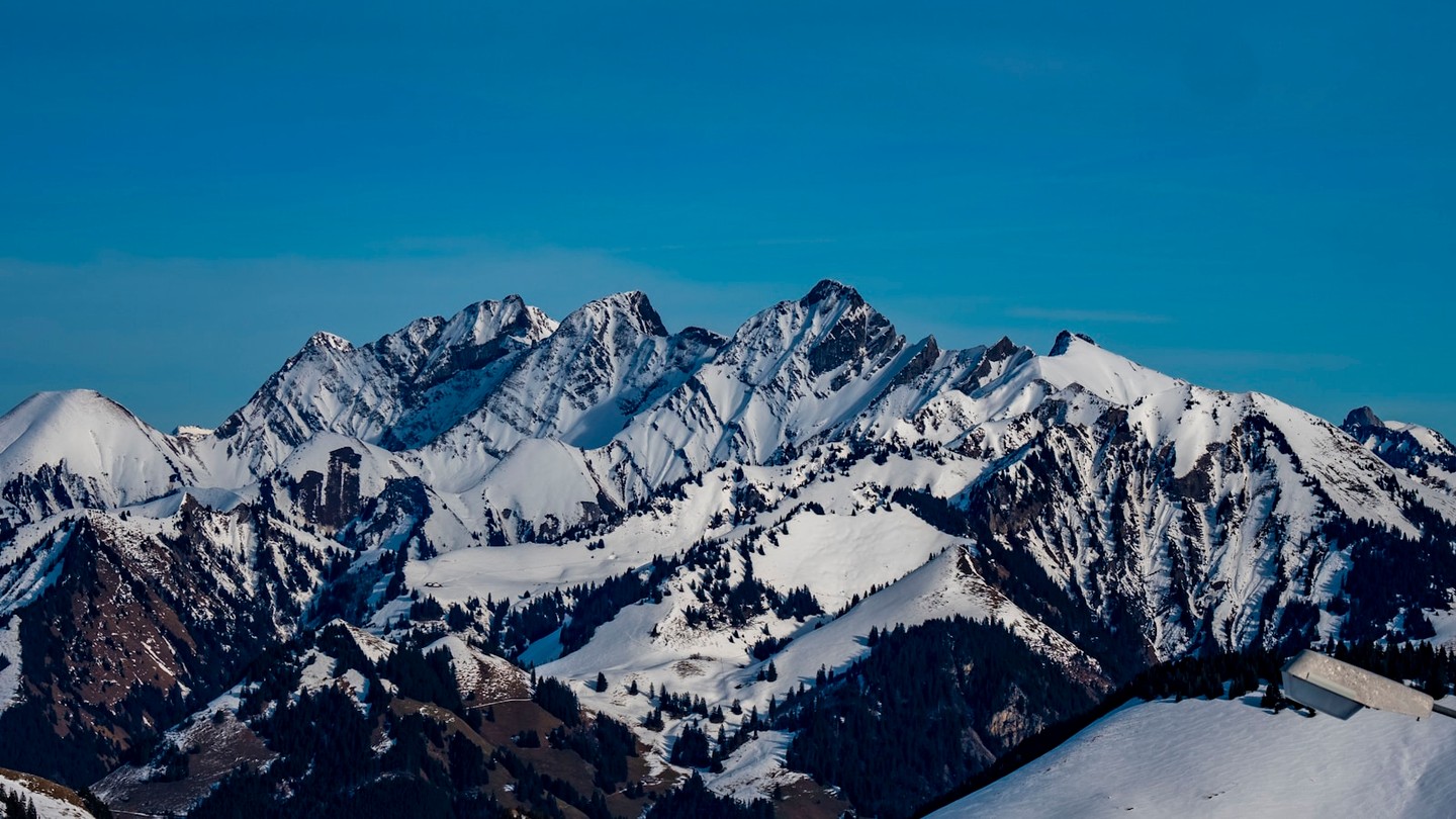 A snow-covered mountain range under a clear blue sky.