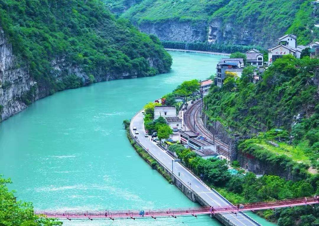 Cyclist riding through the bamboo-lined river valley on the Dayi Xin-Ma-Tai loop near Chengdu