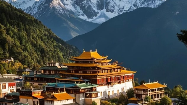 Golden-roofed Tibetan monastery halls on a forested hillside with a snow-capped peak rising behind.