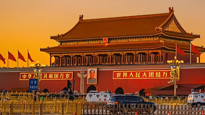 Tiananmen Gate in Beijing at sunset featuring the portrait of Mao Zedong and Chinese architecture.