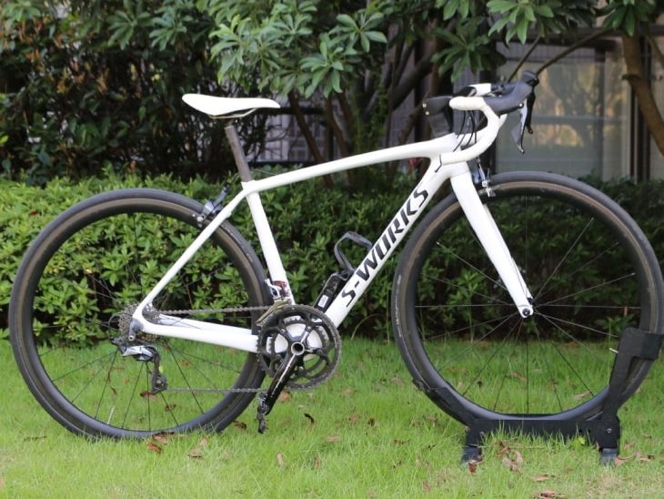 White Specialized S-Works Tarmac carbon fiber road bike parked on a green lawn.