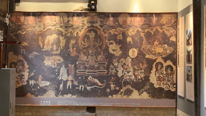 Ancient Buddhist mural inside the Baoshan Temple museum featuring ornate religious art and traditional iconography.