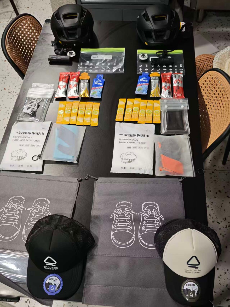 Helmets, energy gels and bars, towels and caps laid out on a table before the ride